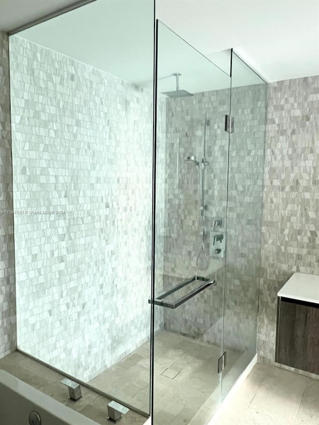 bathroom featuring tile walls, an enclosed shower, and tile patterned flooring