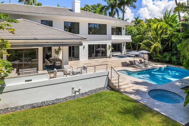 back of house with a patio area and a pool with hot tub