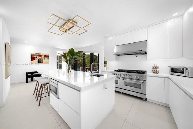 kitchen featuring sink, an island with sink, range hood, white cabinetry, and stainless steel appliances