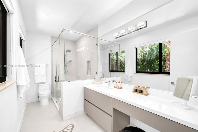 bathroom featuring tile patterned flooring, vanity, toilet, and a shower with door