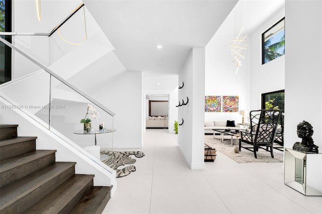 stairs with tile patterned flooring and a high ceiling