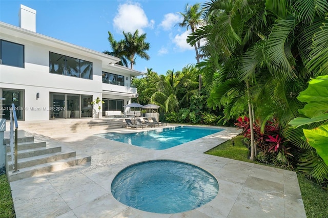 view of pool with a patio and a hot tub