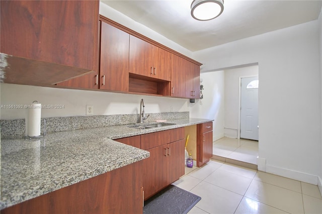 kitchen featuring sink, light stone counters, and light tile patterned floors