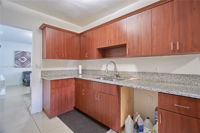 kitchen featuring light tile patterned floors, sink, and light stone countertops