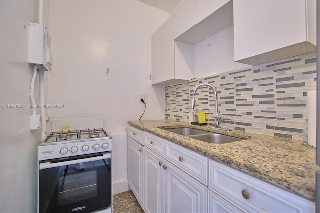 kitchen featuring white cabinetry, light stone countertops, range with gas stovetop, sink, and tasteful backsplash