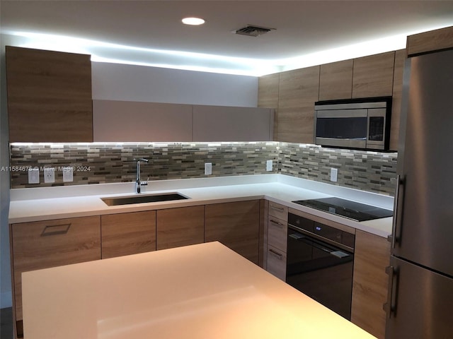 kitchen featuring sink, backsplash, and black appliances