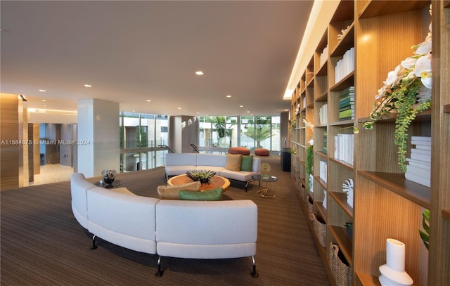 carpeted living room with expansive windows and wood walls