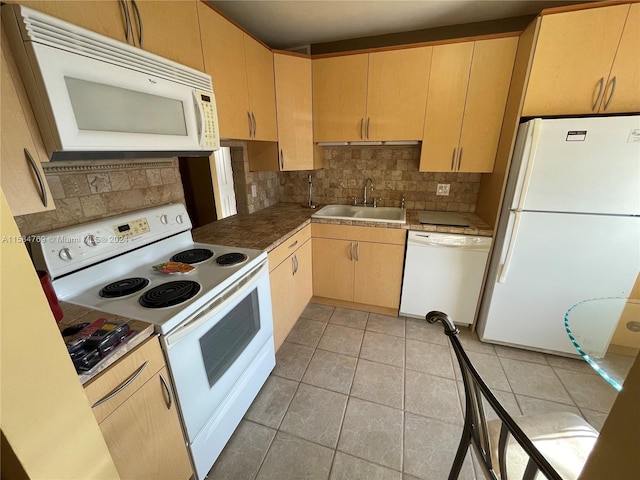 kitchen with decorative backsplash, light tile patterned floors, white appliances, and sink