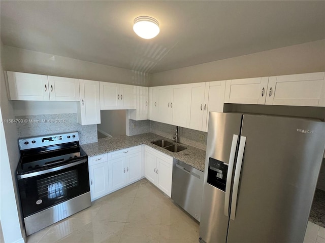 kitchen with tasteful backsplash, stainless steel appliances, sink, stone counters, and white cabinets