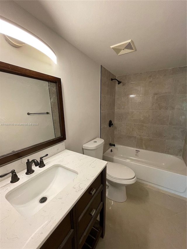 full bathroom featuring vanity, tiled shower / bath combo, and toilet