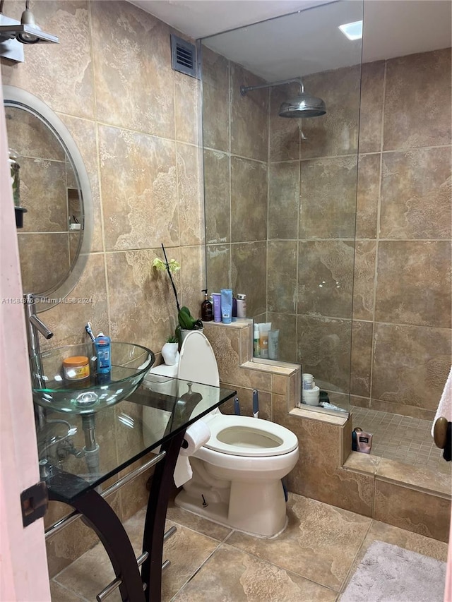 bathroom with sink, tile flooring, toilet, and tile walls