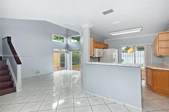 kitchen with tile counters, white appliances, ornamental molding, kitchen peninsula, and light tile floors