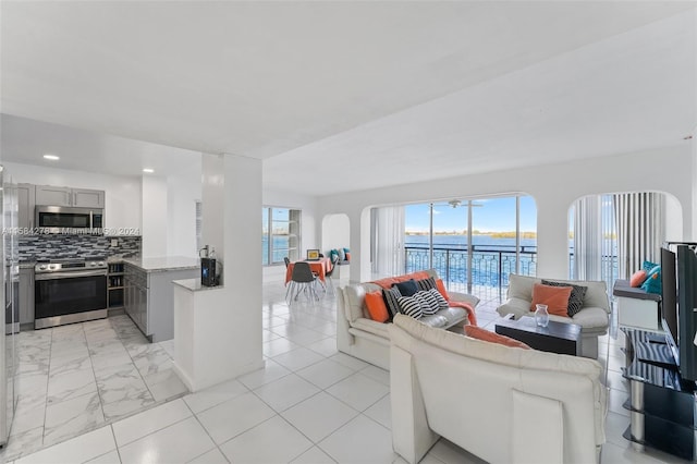 living room featuring a water view and light tile floors