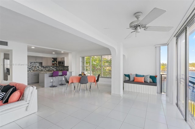 interior space with ceiling fan and light tile floors