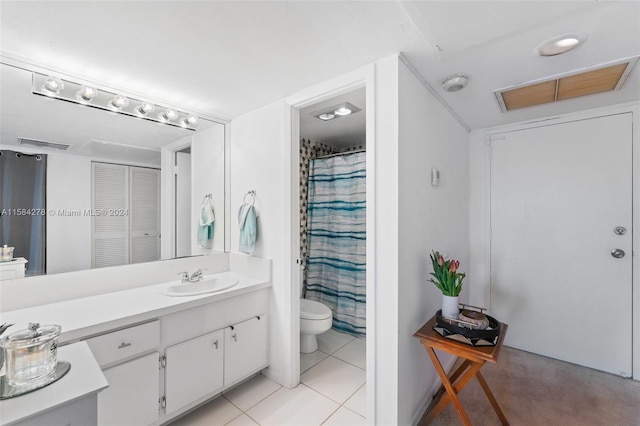 bathroom with vanity, toilet, and tile flooring