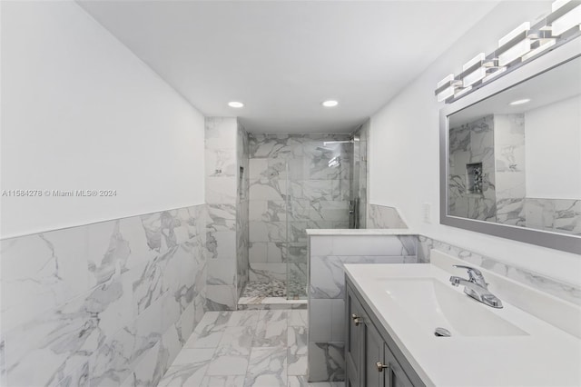 bathroom with tile flooring, vanity with extensive cabinet space, an enclosed shower, and tile walls