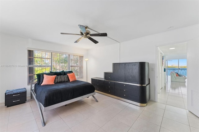 bedroom featuring ceiling fan, access to outside, light tile floors, and multiple windows