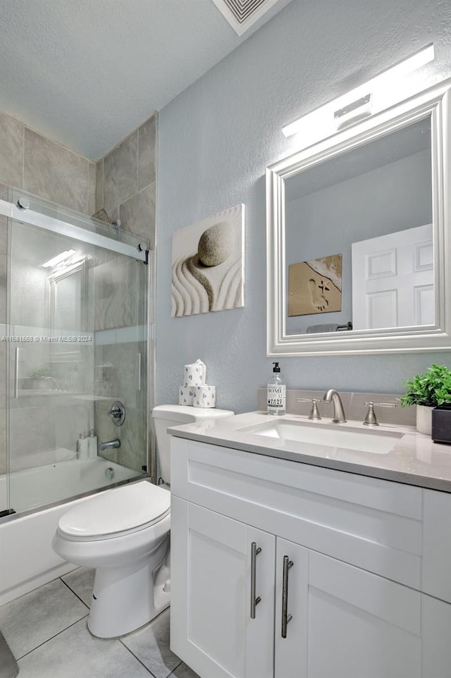 full bathroom with tile flooring, a textured ceiling, enclosed tub / shower combo, toilet, and vanity