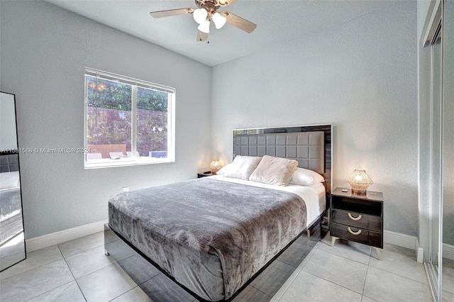 tiled bedroom featuring ceiling fan