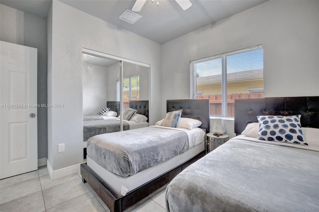 tiled bedroom featuring ceiling fan and a closet