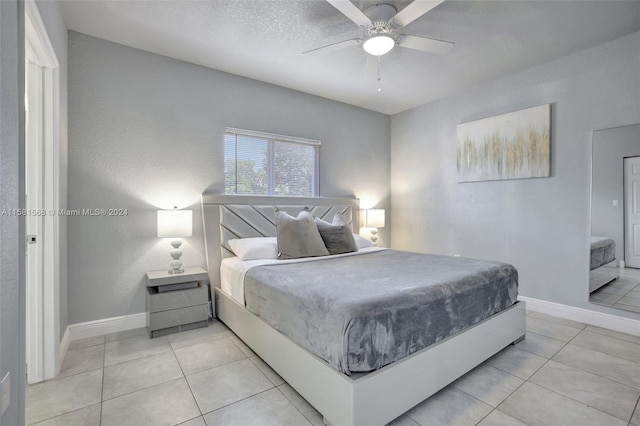 tiled bedroom with a textured ceiling and ceiling fan