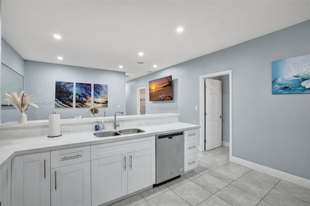 kitchen featuring dishwasher, white cabinetry, sink, and light tile flooring