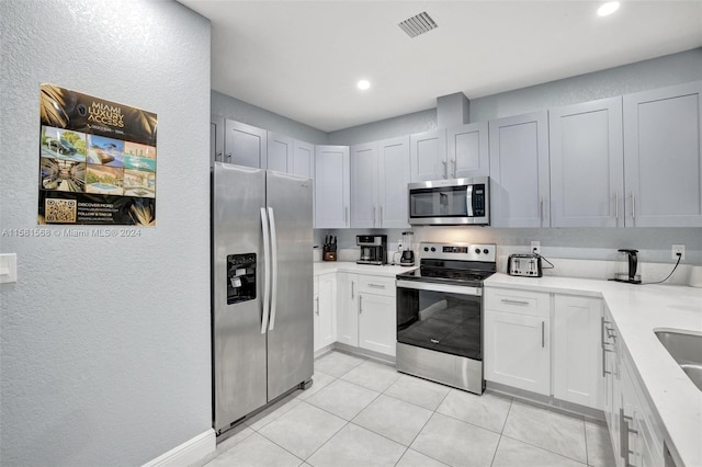 kitchen featuring stainless steel appliances and light tile flooring