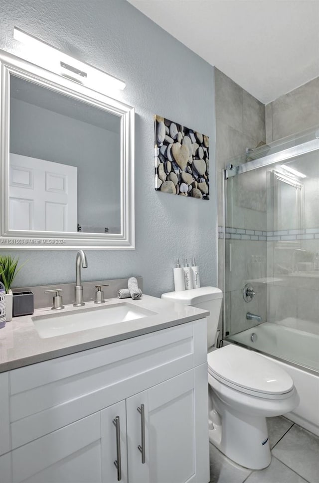 full bathroom featuring shower / bath combination with glass door, vanity, tile floors, and toilet