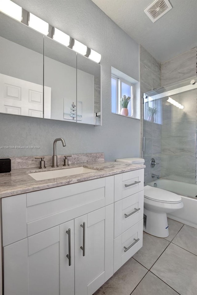 full bathroom featuring toilet, tile floors, vanity, and shower / bath combination with glass door