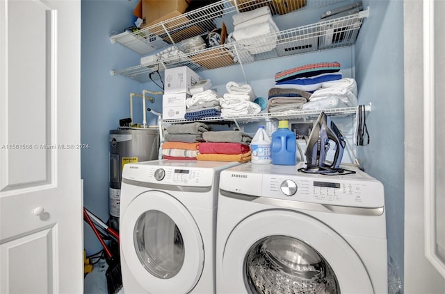 clothes washing area featuring water heater and washer and dryer