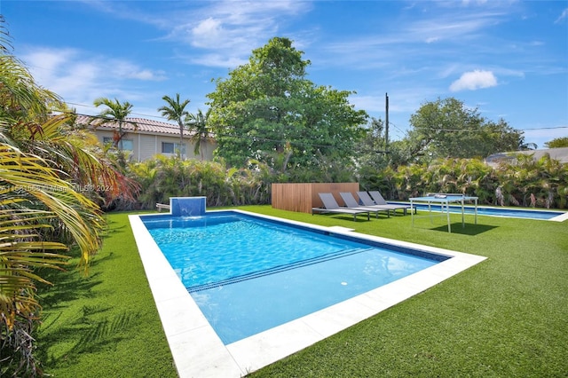 view of swimming pool with a yard