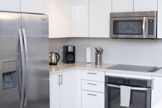 kitchen with sink, white cabinetry, track lighting, and stainless steel dishwasher