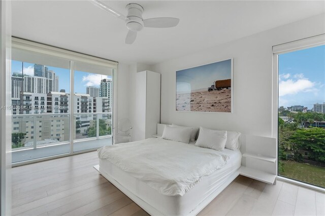 bedroom with light hardwood / wood-style floors, ceiling fan, and access to outside