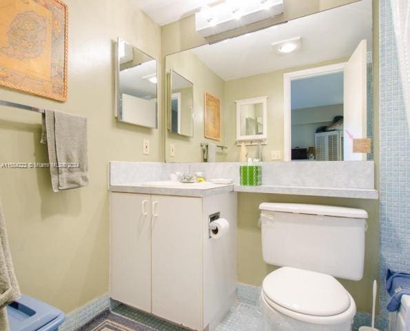 bathroom with tile floors, vanity, and toilet