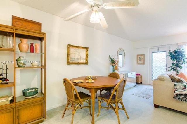 carpeted dining room featuring ceiling fan