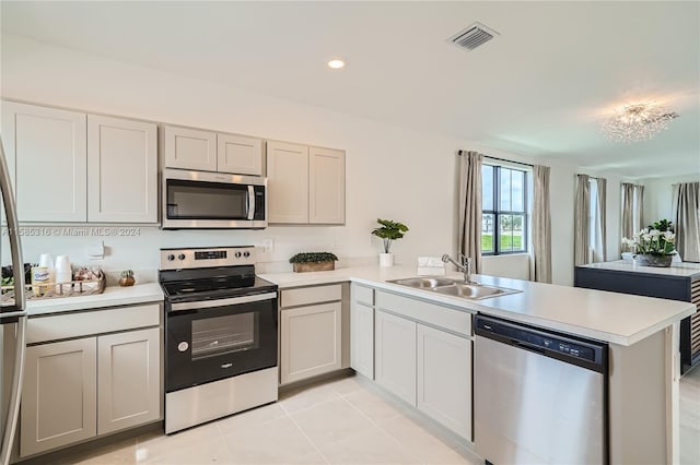 kitchen featuring kitchen peninsula, appliances with stainless steel finishes, sink, and light tile flooring