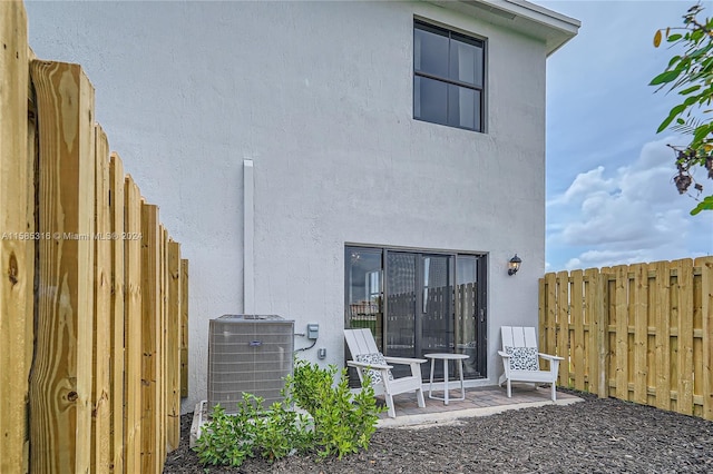 rear view of property with a patio area and central AC unit