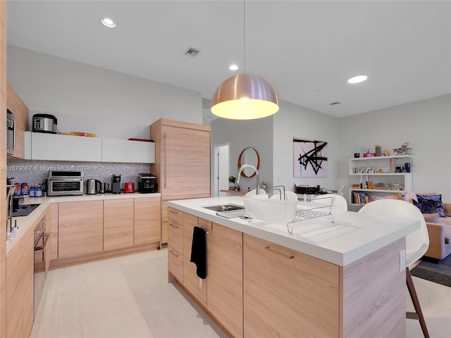 kitchen with pendant lighting, light tile flooring, light brown cabinetry, sink, and tasteful backsplash