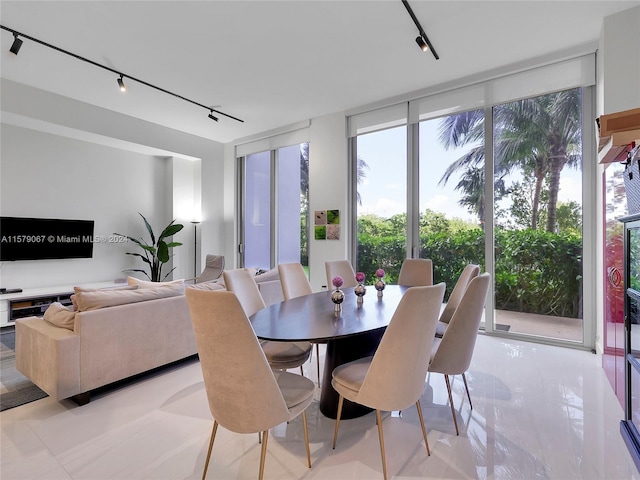 dining room with rail lighting and light tile floors