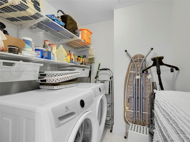 laundry area with washer and clothes dryer and light tile floors