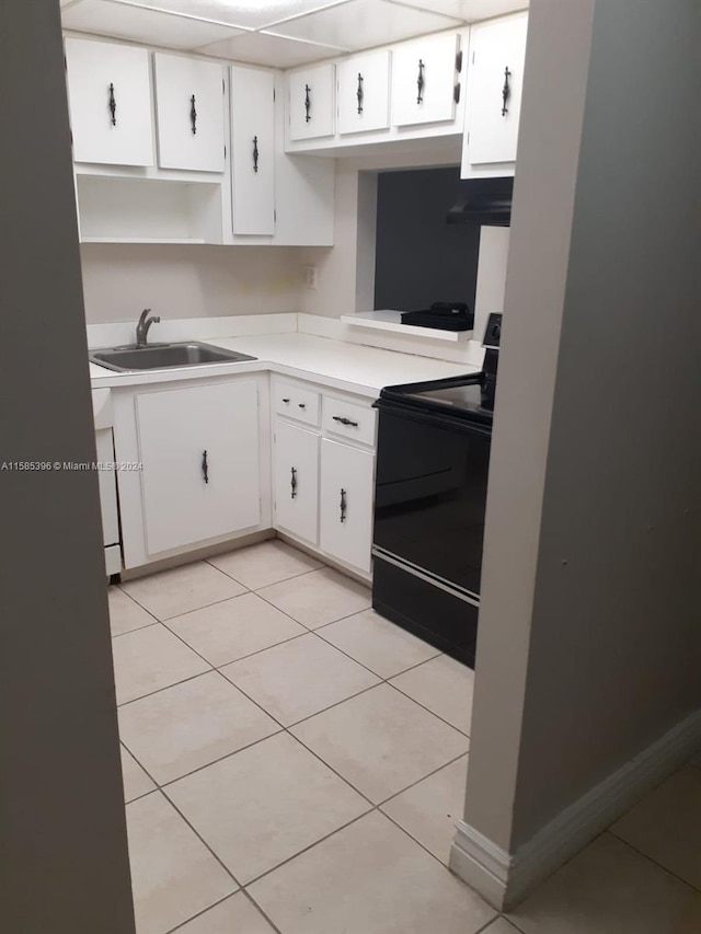 kitchen featuring black range with electric cooktop, white cabinetry, light tile flooring, extractor fan, and sink