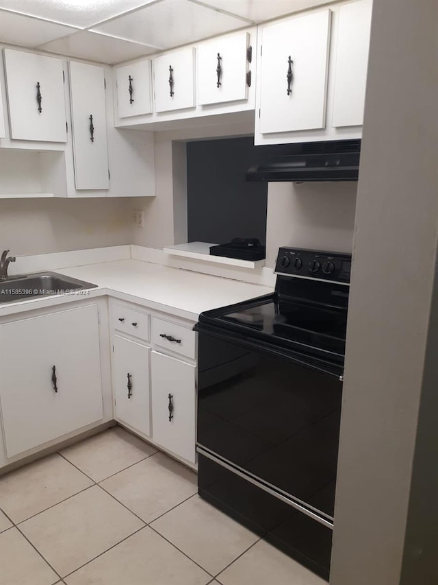 kitchen with fume extractor, white cabinetry, electric range, and light tile floors