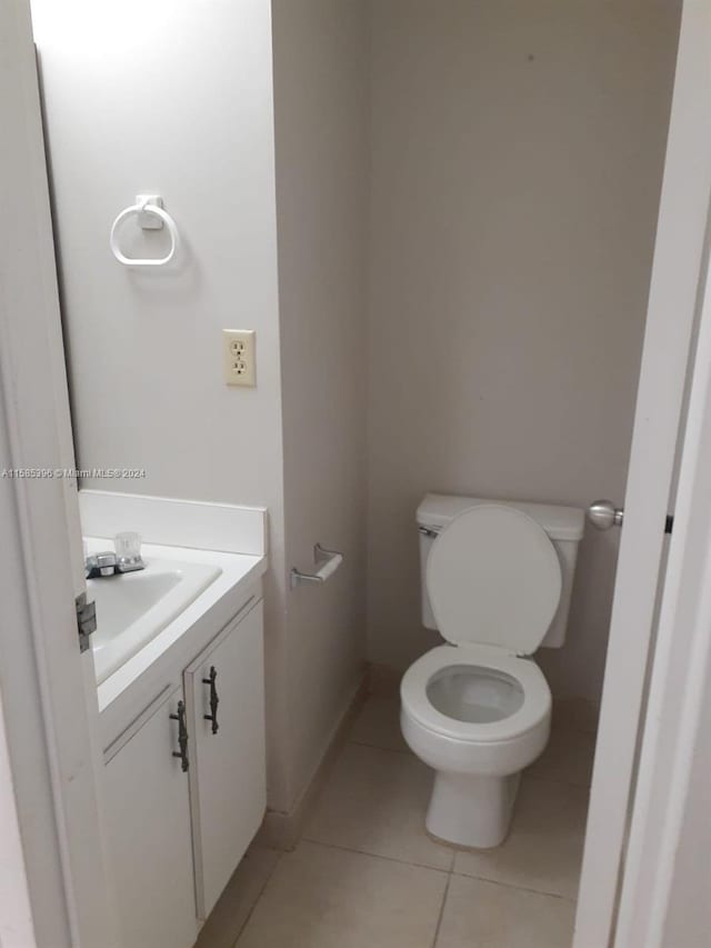 bathroom featuring toilet, tile floors, and vanity