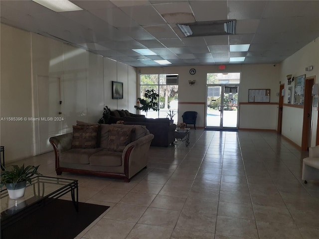 tiled living room featuring a paneled ceiling