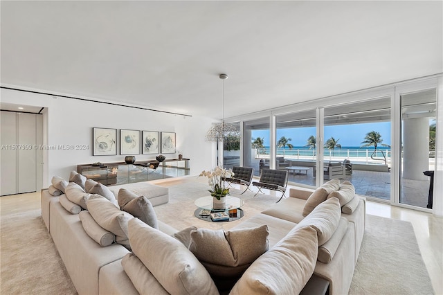 living room with expansive windows, a water view, and plenty of natural light