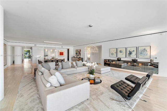 living room featuring light hardwood / wood-style floors and a chandelier