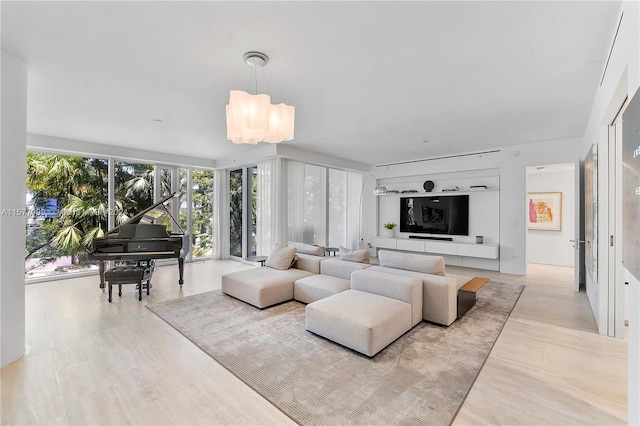 living room with light hardwood / wood-style flooring and an inviting chandelier