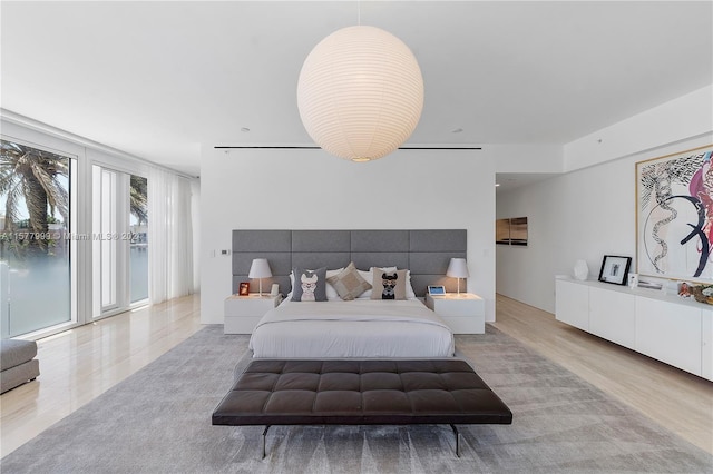 bedroom with access to exterior and light wood-type flooring