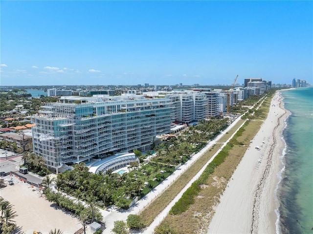 birds eye view of property with a water view and a beach view