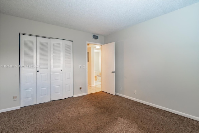 unfurnished bedroom with a closet, carpet, and a textured ceiling